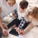 Parents and child enjoying drawing together on the floor, creating memories.
